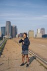Jovem atleta masculino hispânico com os olhos fechados de pé na berma da estrada no centro de Dallas, Texas — Fotografia de Stock