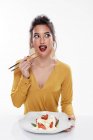 Senhora com maquiagem moderna degustação de alimentos com pauzinhos — Fotografia de Stock