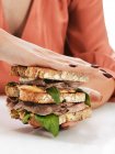 Mujer anónima con sabroso sándwich doble en las manos - foto de stock