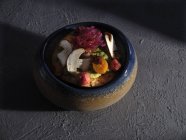 Riesige Schüssel voller Salat mit halbierten Pilzen und Gemüse auf Zementoberfläche — Stockfoto