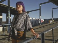 Стильна жінка з фіолетовою зачіскою в модному піджаку на вулиці в яскравий день — стокове фото