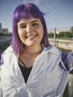 Mode femme élégante avec coiffure violette dans le centre-ville regardant en toute confiance dans la caméra et souriant — Photo de stock