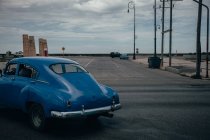 Пересечение асфальтированной дороги с голубым винтажным автомобилем среди современных транспортных средств в центре Кубы — стоковое фото