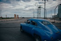 Asphalt road intersection with blue vintage car among contemporary transports in middle in Cuba — Stock Photo