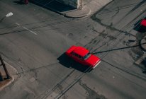 D'en haut de l'intersection de la route asphaltée avec voiture vintage rouge parmi les transports contemporains au milieu de Cuba — Photo de stock