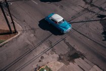 Desde arriba de carretera asfaltada intersección con coche rojo vintage entre transportes contemporáneos en medio en Cuba - foto de stock