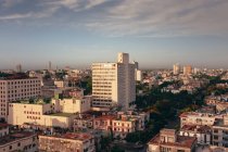 Desde arriba de coloridos edificios y rascacielos con cielo azul sobre fondo en las calles de Cuba - foto de stock