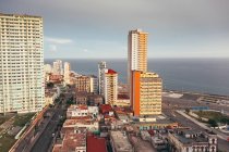 De cima de edifícios coloridos e arranha-céus com céu azul no fundo em ruas de Cuba — Fotografia de Stock
