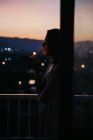 Vue latérale de la jeune femme sans visage allumant cigarette avec magnifique coucher de soleil sur fond flou — Photo de stock
