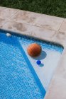 De cima de bola de basquete no canto na piscina no terraço da casa com grama verde — Fotografia de Stock