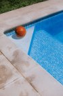 Зверху баскетбольний м'яч у кутку на басейні в терасі будинку з зеленою травою — стокове фото