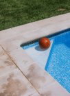 Зверху баскетбольний м'яч у кутку на басейні в терасі будинку з зеленою травою — стокове фото