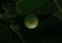 Drone vista de bosque verde y campos en el campo y globo de aire caliente a la luz del sol - foto de stock