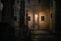 Каменный забор с крестами, расположенный в смутно освещенном внутреннем дворе старого собора в темную ночь в Бургосе, Испания — стоковое фото