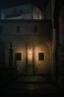 Valla de piedra con cruces situada en el patio débilmente iluminado de la antigua catedral en la noche oscura en Burgos, España - foto de stock