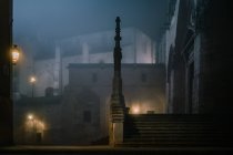 Clôture en pierre illuminée autour de l'ancien bâtiment de la cathédrale lors d'une nuit sombre et brumeuse à Burgos, Espagne — Photo de stock