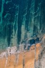 Dall'alto paesaggio sereno di onde turchesi lavare sabbia spiaggia tranquilla in Pielagos, Cantabria, Santander, Spagna — Foto stock