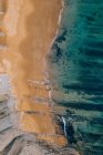 From above serene landscape of turquoise waves washing sandy calm beach in Pielagos, Cantabria, Santander, Spain — Stock Photo