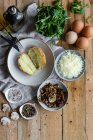 Draufsicht auf gefüllte Kartoffeln auf Holztisch mit gebratenen Champignons geriebenem Käse und Kräutern — Stockfoto