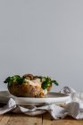 Œuf frit sur pomme de terre sur table en bois avec champignons frits fromage râpé et herbes — Photo de stock