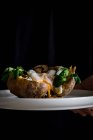 De cima do boliche cerâmico branco com ervas de cogumelos de ovo fritas saborosas na batata na mão de colheita — Fotografia de Stock