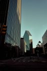 Leere Asphaltkreuzung inmitten großer Glasgebäude mit blauem Himmel im Hintergrund in der Abenddämmerung in Dallas, Texas New York — Stockfoto