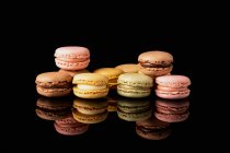 Macaroni gustosi colorati impilati visualizzati su sfondo nero — Foto stock