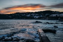 Waves washing old molo in shore under cloudy sunset sky in Girona, Catalogna, Spain — Foto stock