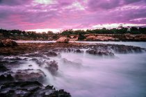 Mystérieux paysage de rivage rocheux vide avec brouillard sous un ciel nuageux de couleur lilas — Photo de stock