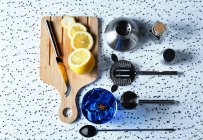 Top view of blue cocktail with ice cubes and sliced lemon on wooden board with barman tools on table — Stock Photo