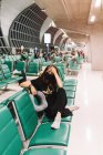 Frustrada turista feminina com máscara tocando cabeça no aeroporto — Fotografia de Stock