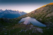 Lago di cristallo e tenda in montagne innevate alla luce del sole — Foto stock