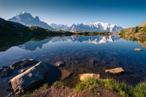 Хрустальное озеро, отражающее снежные горы в яркий день — стоковое фото