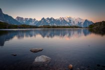 Kristallsee reflektiert verschneite Berge bei hellem Tag — Stockfoto