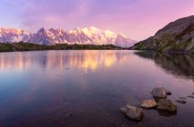 Lac cristallin reflétant les montagnes enneigées par beau temps — Photo de stock