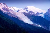 Білі гострі гірські вершини в снігу піднімаються до хмарного неба — стокове фото