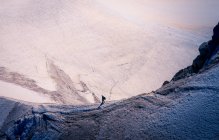 Вид сбоку активного туриста, прогуливающегося по скалистым белым горам в яркий день в Шамони, Мон-Блан — стоковое фото