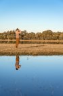 Seitenansicht eines unkenntlichen Mannes, der durch ein altes Fernglas die Fauna einer Lagune in Spanien betrachtet — Stockfoto
