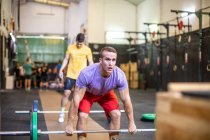 Musclé levant haltère dans la salle de gym moderne — Photo de stock
