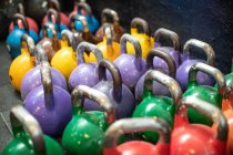 Shabby kettlebells on grass mat in gym — Stock Photo