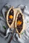 De acima mencionados ovos de laranja em kachapuri saboroso com ervas em suporte de madeira com faca e garfo em linho à mesa — Fotografia de Stock