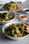 De arriba el plato sabroso cocido con el arroz y las judías verdes que sirven en los platos con los condimentos a la mesa - foto de stock