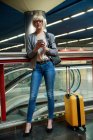 Businesswoman with luggage talking on phone — Stock Photo