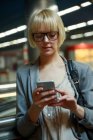 Женщина просматривает смартфон на станции — стоковое фото
