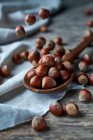 From above tasty fresh gathered hazelnuts on wooden spoon on linen at table — Stock Photo