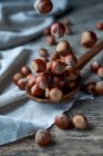 Brown ripe hazelnuts on spoon at table — Stock Photo