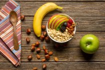 Apple and banana with nuts on wooden table — Stock Photo