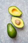 Schneiden Sie Avocado auf grauem Hintergrund — Stockfoto