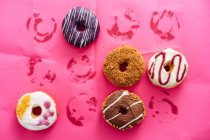 Variedade de donuts no fundo rosa — Fotografia de Stock