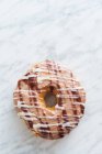 Draufsicht auf traditionellen süßen Donut mit Sahnehäubchen auf heller Marmoroberfläche — Stockfoto